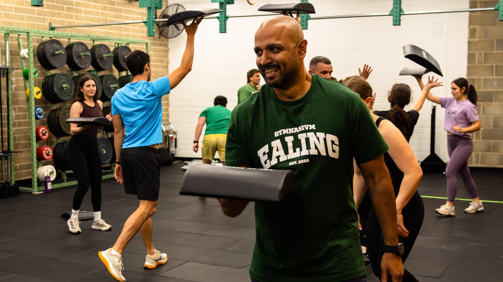 Coach smiling with his class mid-session at Gymnasium Ealing