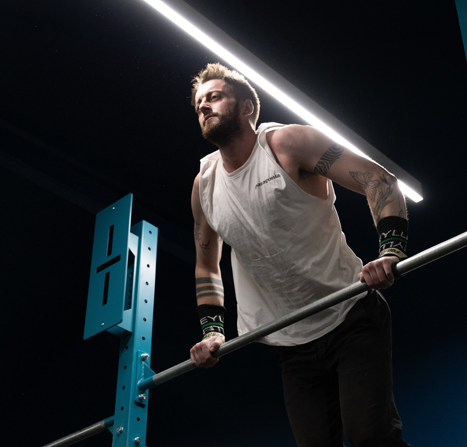 Member focused mid-rep on the pull-up bar at Gymnasium
